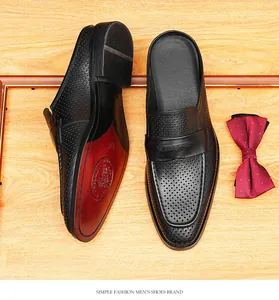 Detalle de mocasines de cuero perforado negro con suela roja