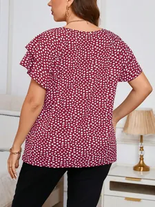 Rear view of women's red blouse with white irregular polka dots and ruffled sleeves