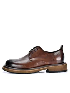 Vista lateral de zapatos Derby de cuero marrón pulido con suelas gruesas con estilo