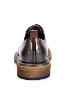 Vista posterior de zapato de hombre en cuero marrón con detalle de textura del talón
