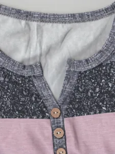 Détail d'un t-shirt rayé décontracté avec boutons en bois et encolure en V