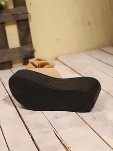 Dettaglio della suola a zeppa nera strutturata di questi eleganti sandali con plateau