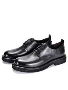 Primer plano detallado que muestra la textura del cuero genuino negro en zapatos de vestir.