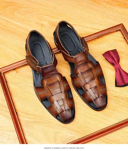Detailed shot of premium brown woven closed-toe men's leather sandals on wood background