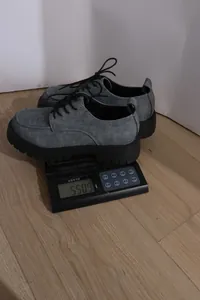 Grauer Plateau-Loafer im Denim-Stil auf einer digitalen Waage gewogen, Gewicht 550,9 g