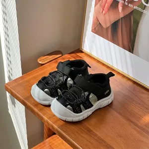 Primer plano de sandalias negras transpirables para niños con punta cerrada