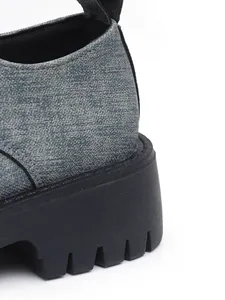 Nahaufnahme eines Damen-Loafers mit klobiger Profilsohle und grauem Obermaterial.