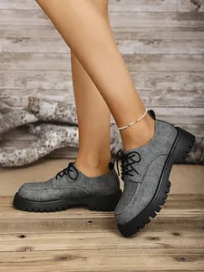 Detailansicht der grauen Loafer mit dicker Sohle an einem Modell in rustikalem Ambiente