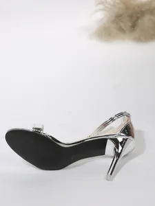 Side detail view of silver metallic stiletto heel and black sole of elegant high-heeled sandal