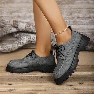 Nahaufnahme grauer Plateau-Oxfordschuhe aus Stoff mit dicker Sohle für den Retro-Look.