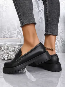 Detailansicht der schwarzen Plateau-Loafer für Damen mit dicker Sohle und Slip-On-Design.