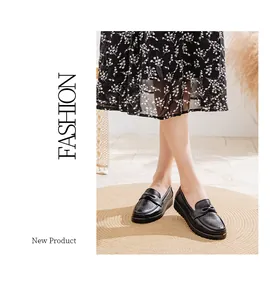 Close-up of black leather loafers with bow detail and breathable perforations for women