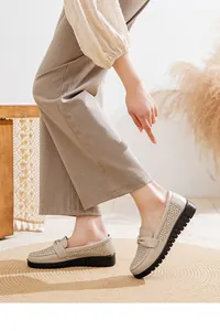 Close-up detail of beige hollow-out leather loafers for women with comfortable soft soles
