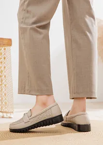 Close-up side view of beige perforated leather loafers for women with soft soles