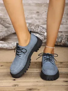 Nahaufnahme von blauen Denim-Schuhen im britischen Stil mit dicker Profilsohle