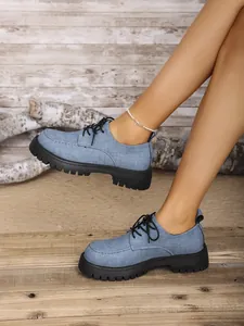 Nahaufnahme von blauen Plateau-Loafers in Denim-Optik mit dicken schwarzen Sohlen