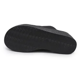 Détail de la semelle antidérapante texturée ondulée de ces mules compensées de plage noires