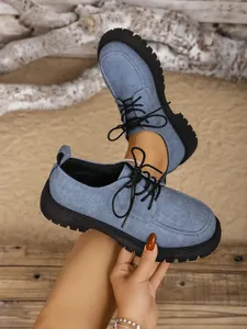 Detailansicht blauer Denim-Schnürschuhe mit dicker schwarzer Plateausohle im Vintage-Stil