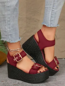 Detailed view of burgundy mesh platform wedge sandals with elegant gold buckle straps