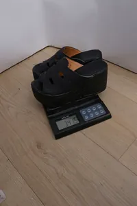 Mesure détaillée du poids d'une sandale à talons compensés noirs pesant environ 341,5 grammes