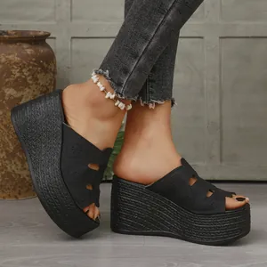 Gros plan sur des sandales compensées noires pour femmes avec un design ajouré floral