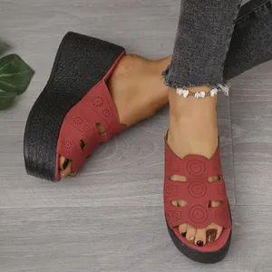 Vue détaillée de sandales à talons compensés rouges avec motifs découpés et bout ouvert