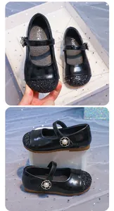 Dettaglio di scarpe Mary Jane nere per bambine con punta glitterata e fibbia di perle