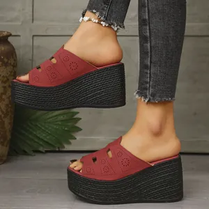 Sandales compensées rouges avec découpes laser portées par un modèle en extérieur