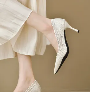 Vista detallada del delicado bordado de encaje en elegantes zapatos de novia blancos