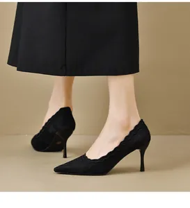 Detalle elegante de tacones de punta en encaje negro con bordes festoneados y tacón fino