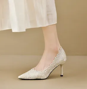 Detalle de elegantes tacones de encaje beige con punta fina y bordados delicados