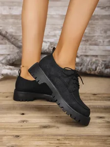 Detaillierte Seitenansicht der schwarzen Canvas-Plateau-Oxfords mit klobiger Sohle