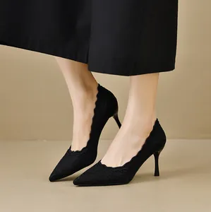 Primer plano de tacones de aguja en encaje negro con elegantes bordados festoneados