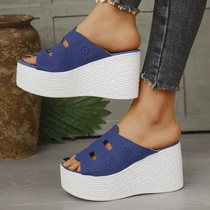 Vue latérale de sandales à talons compensés bleues avec motifs floraux découpés au laser