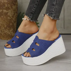 Détail de sandales compensées bleues avec motifs découpés et semelles tressées