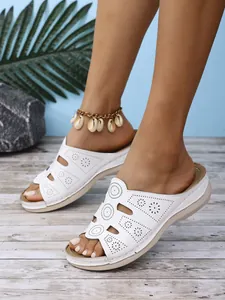 Gros plan de claquettes blanches à plateforme pour femmes avec motifs bohèmes ajourés
