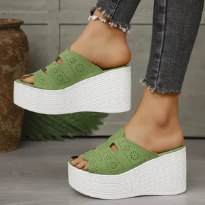 Gros plan de sandales compensées vert femme avec détails floraux découpés au laser