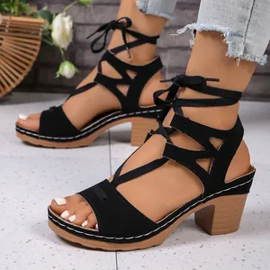 Vista laterale di sandali stringati neri con tacco a blocco e design peep-toe