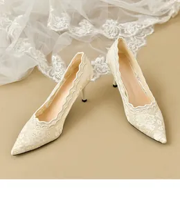 Vista detallada de elegantes zapatos de novia de encaje blanco con bordado floral