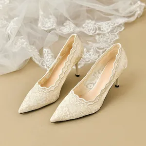 Detalle de elegantes zapatos de novia de encaje marfil con punta y tacón de aguja
