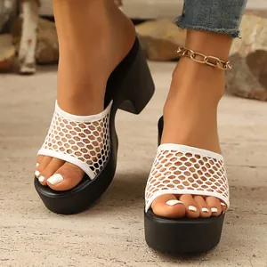 Close-up of women's white mesh platform slippers with chunky high heels