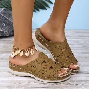 Vue détaillée de sandales compensées kaki avec motifs découpés au laser sur pieds