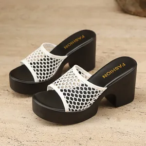 Detailed macro view of black platform slide sandals with white mesh upper and chunky high heel