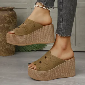 Gros plan sur des sandales compensées kaki avec motifs floraux découpés au laser
