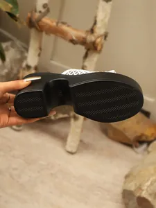 Detailed view of the wave-textured outsole and chunky platform heel of these mules