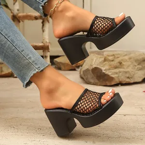 Detail of black mesh platform slides with chunky high heel on a rustic background