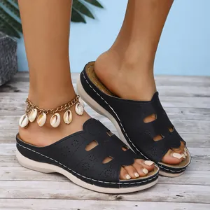 Gros plan de mules noires pour femmes à semelles épaisses avec une chevillère décorative