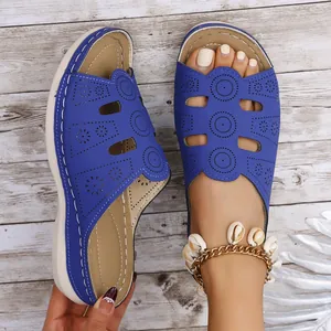 Détail rapproché de sandales à plateforme bleues avec motifs découpés au laser
