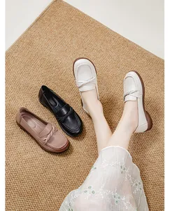 Comfortable flat loafers for women in white, black, and brown on textured rug