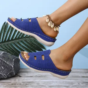 Vue détaillée des sandales compensées bleues avec motifs ajourés portées par un mannequin.